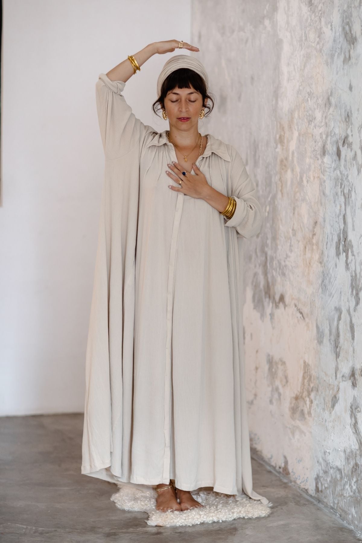 Woman wearing the Kundalini Gown by Myrah Penaloza — full-length bamboo rayon button-down dress with side pockets, flowing sacred feminine silhouette. Handcrafted in Bali for Kundalini yoga and ceremony.