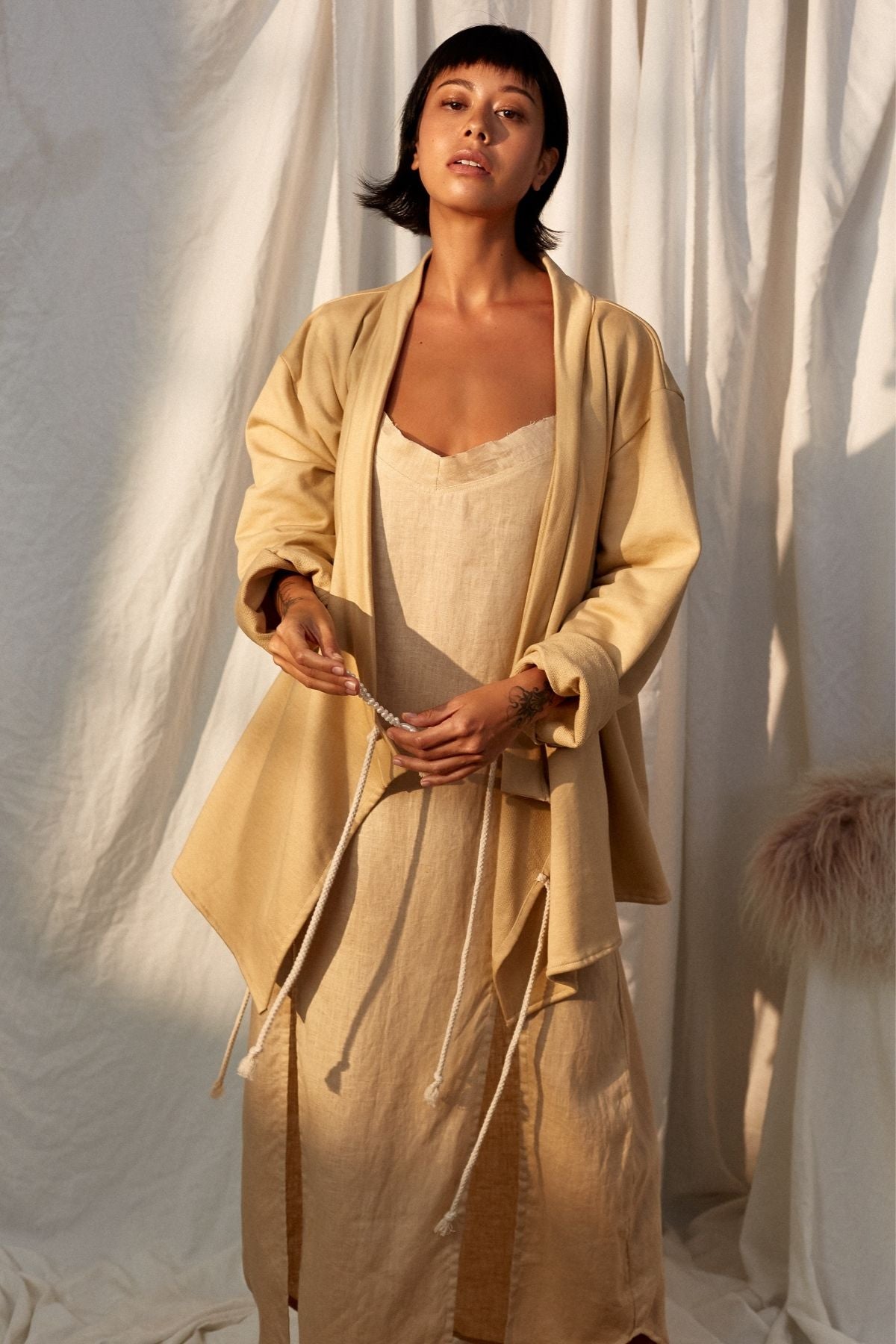 Worn open, showing the Chai Ba Cotton Wrap Jacket by Myrah Penaloza in cotton, handcrafted in Bali by artisan families.