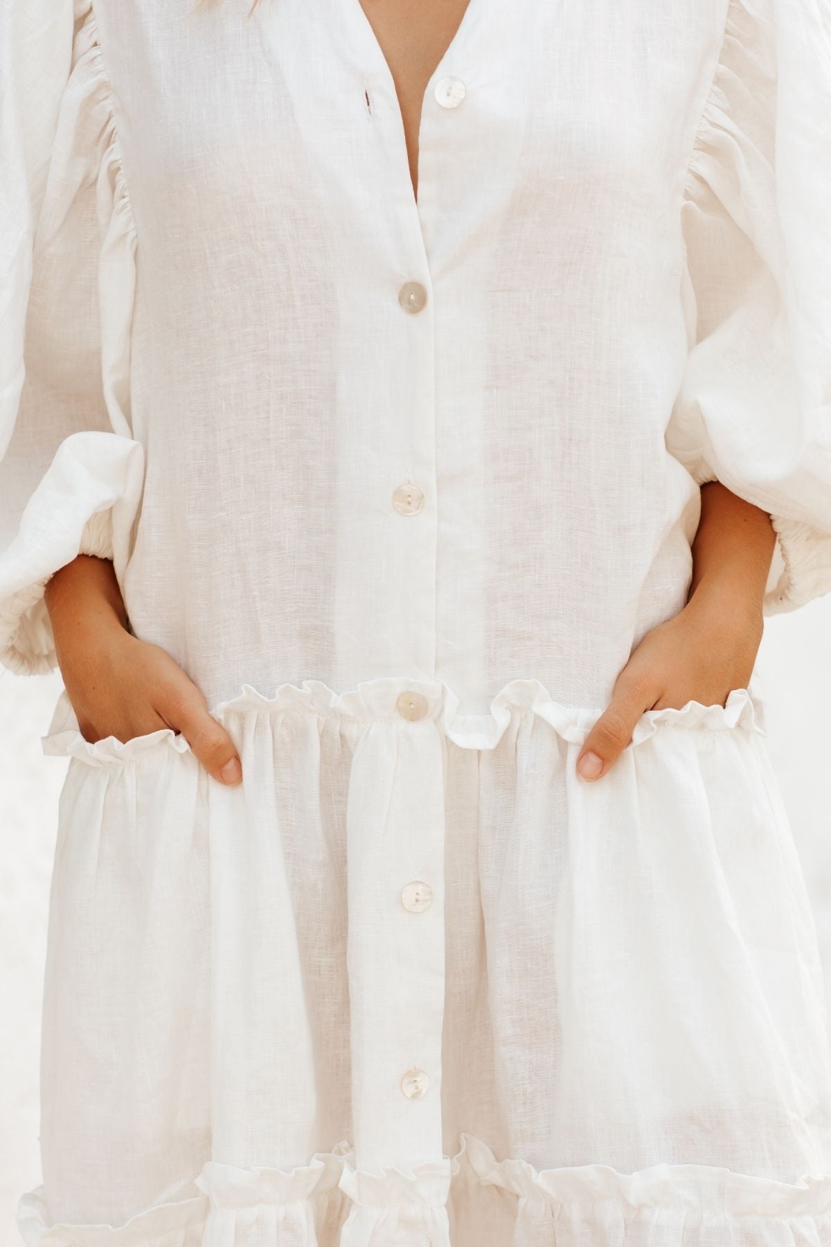 Woman in movement wearing the La Dama with collar by Myrah Penaloza in linen, handcrafted in Bali by artisan families.
