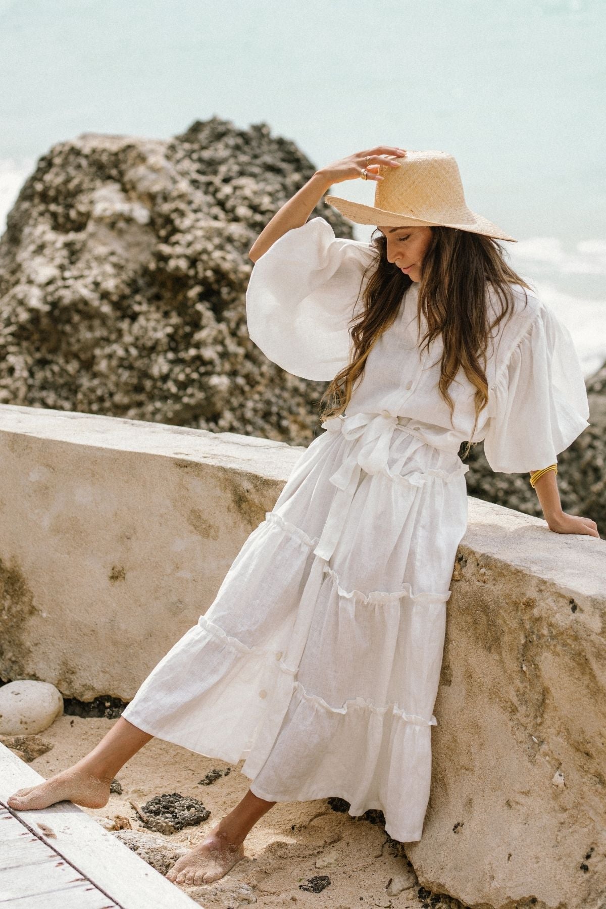Seated view of the La Dama with collar by Myrah Penaloza in linen, handcrafted in Bali by artisan families.