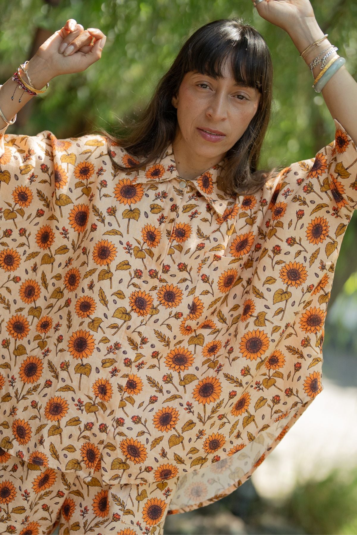 Close view of the oversized sunflower linen top from the Sun Offering Suka Set, arms raised overhead