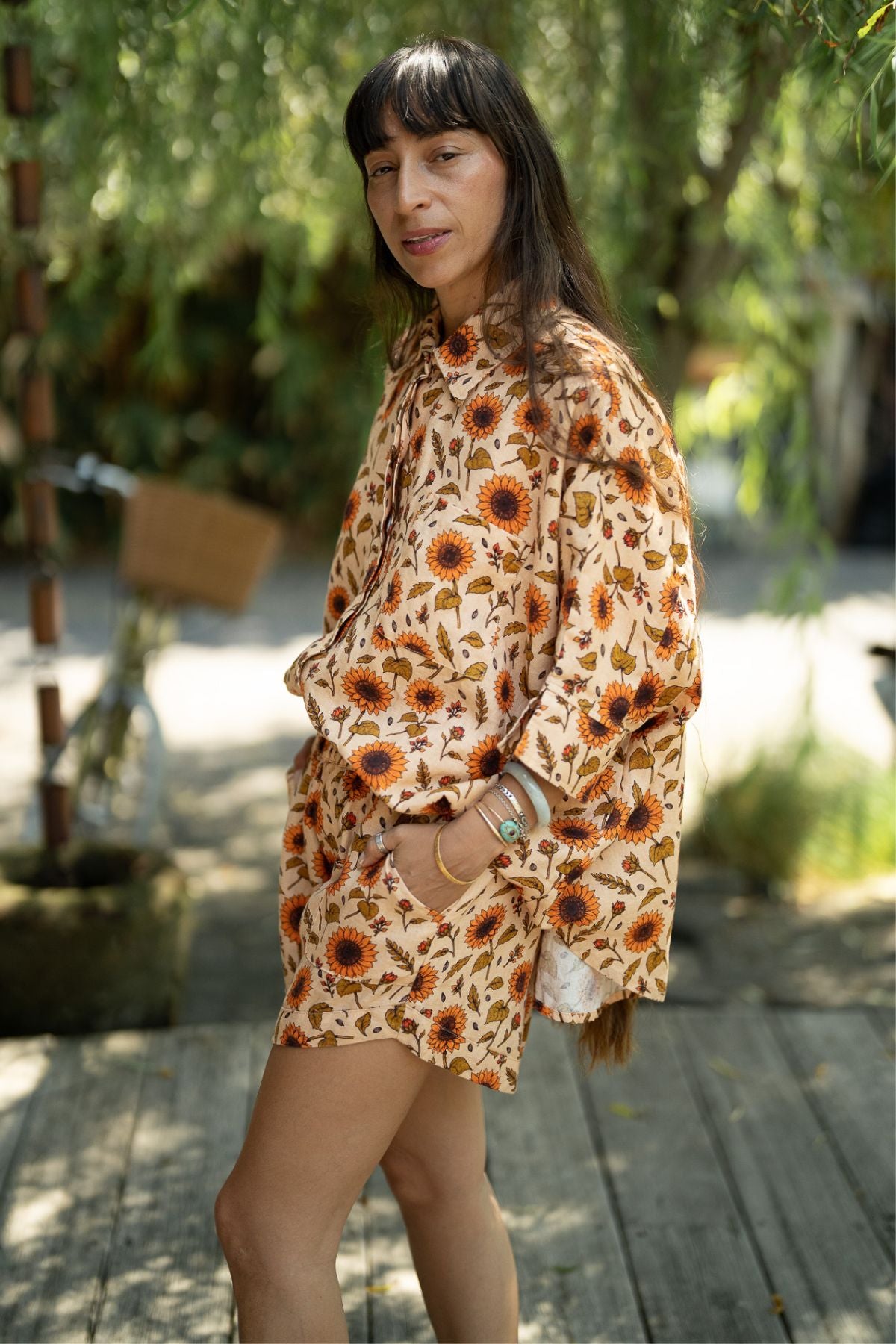 Side view of the Sun Offering Suka Set, sunflower linen top and shorts with one hand in the pocket
