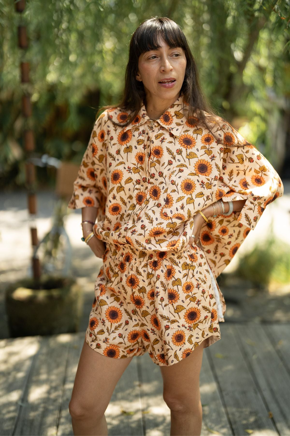The Sun Offering Suka Set in sunflower print linen, worn with hands on hips, front view