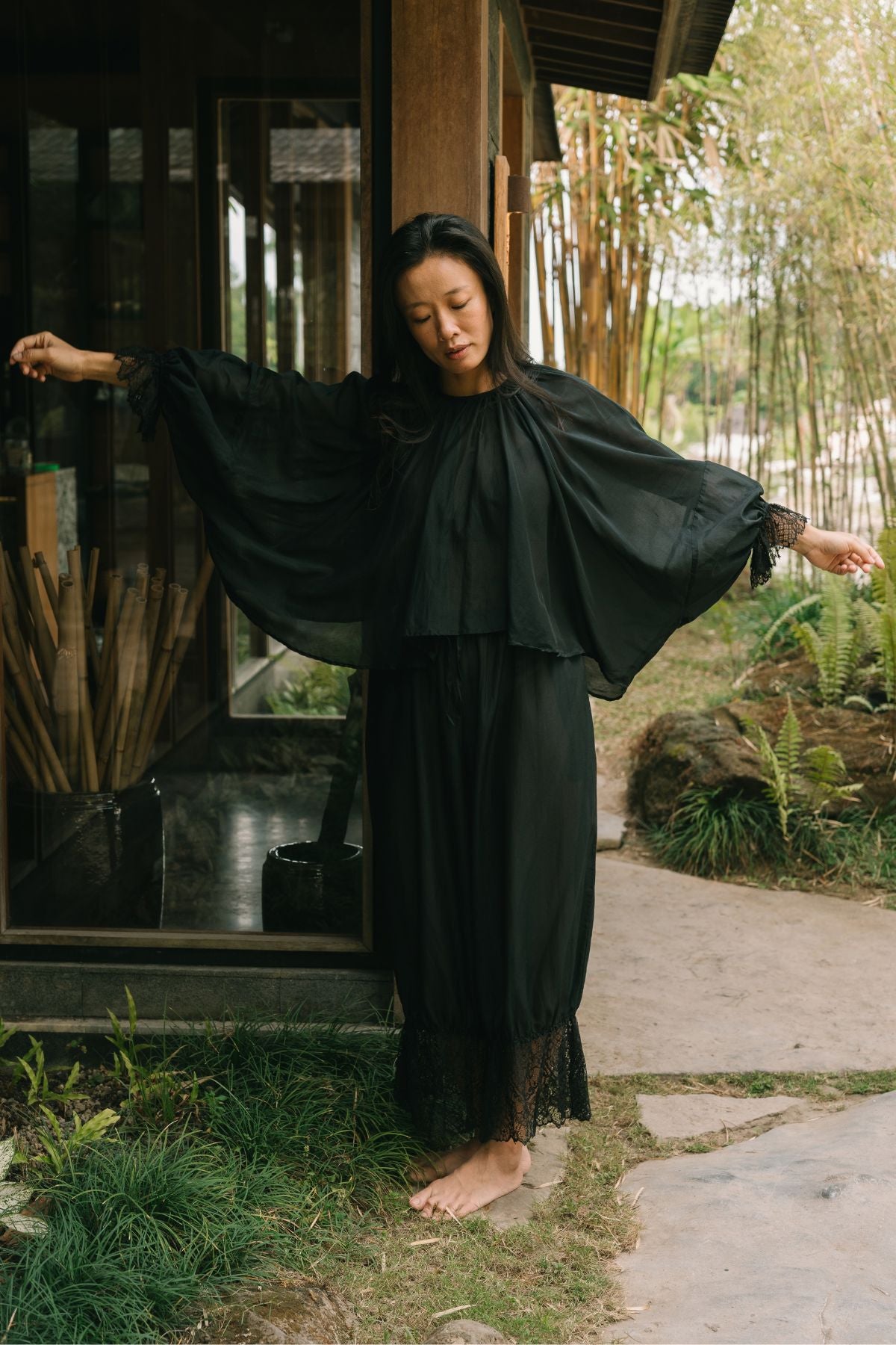 Arms outstretched in the Anusara Evening Set, the wide silk and cotton sleeves open like wings, with hand woven lace at the pant hem.
