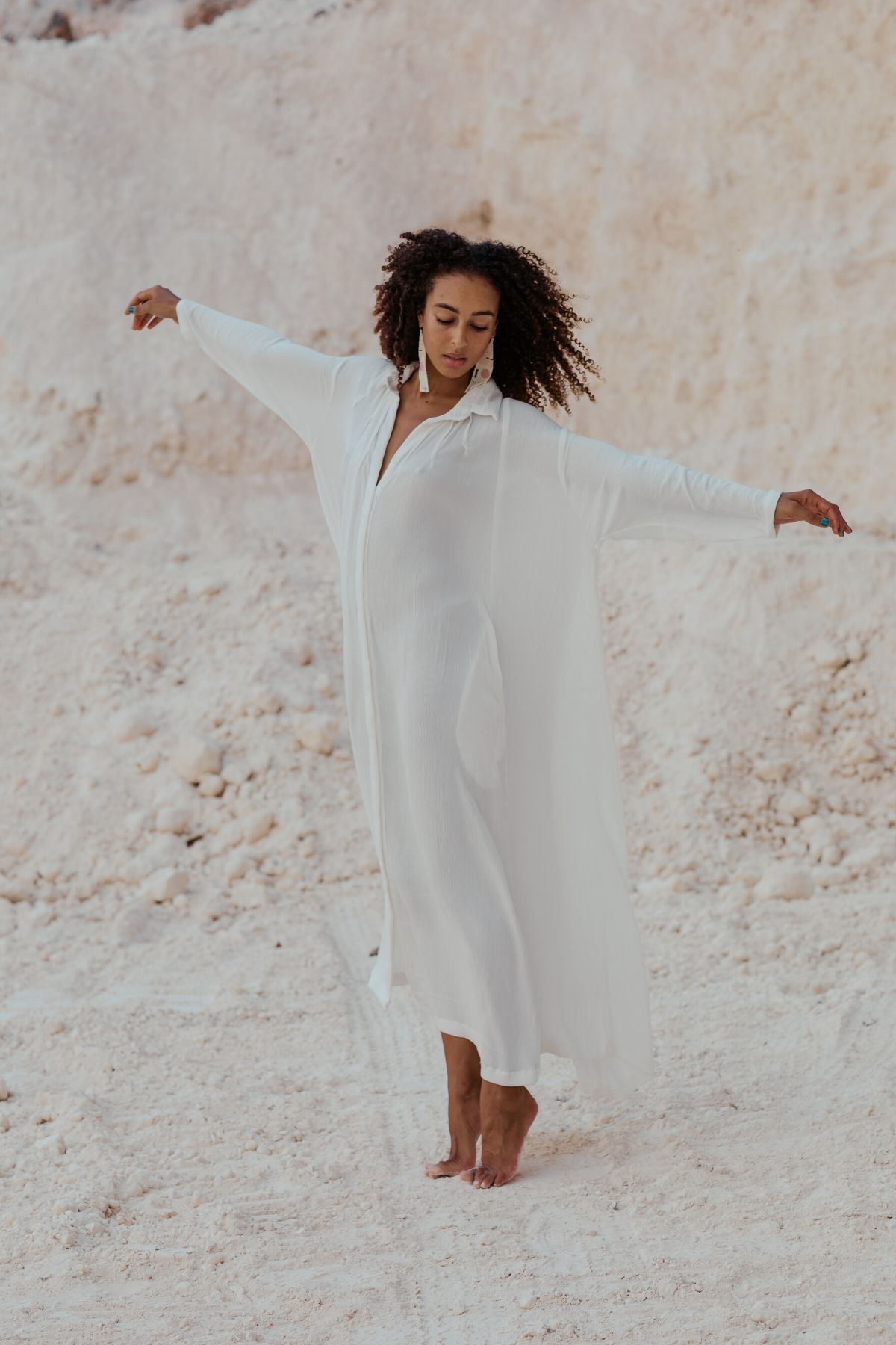 Woman in movement wearing the Kundalini Gown by Myrah Penaloza, handcrafted in Bali by artisan families.